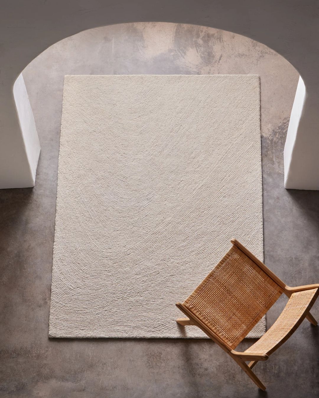 Didelis baltas kilimas Orma – abstrakčiu raštu iš vilnos ir džiuto, švelnios tekstūros moderniam interjerui.