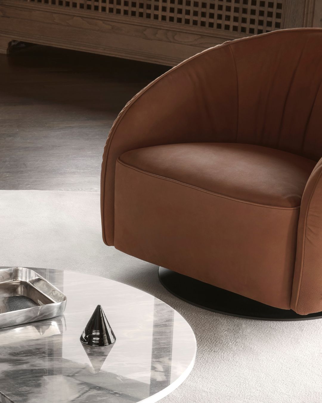 Nest fotelis iš Nicoline – apvalių, apgaubiančių formų, su žemu atlošu ir besisukančia baze