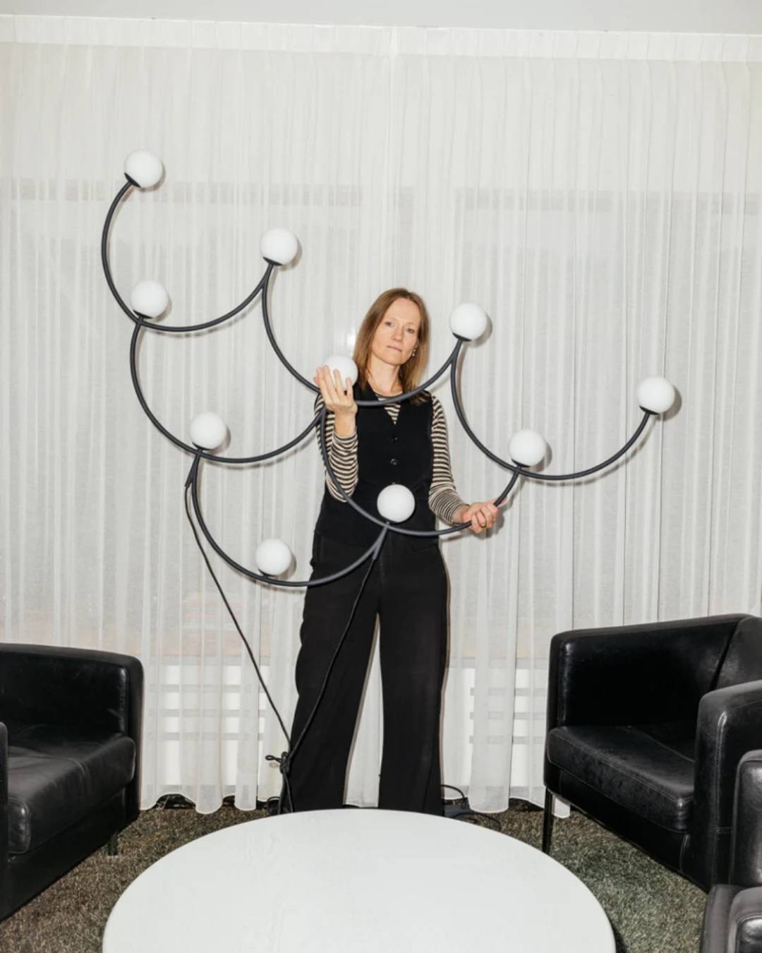 Žaismingų formų pakabinamas šviestuvas su juodo metalo korpusu ir opaliniais stiklais