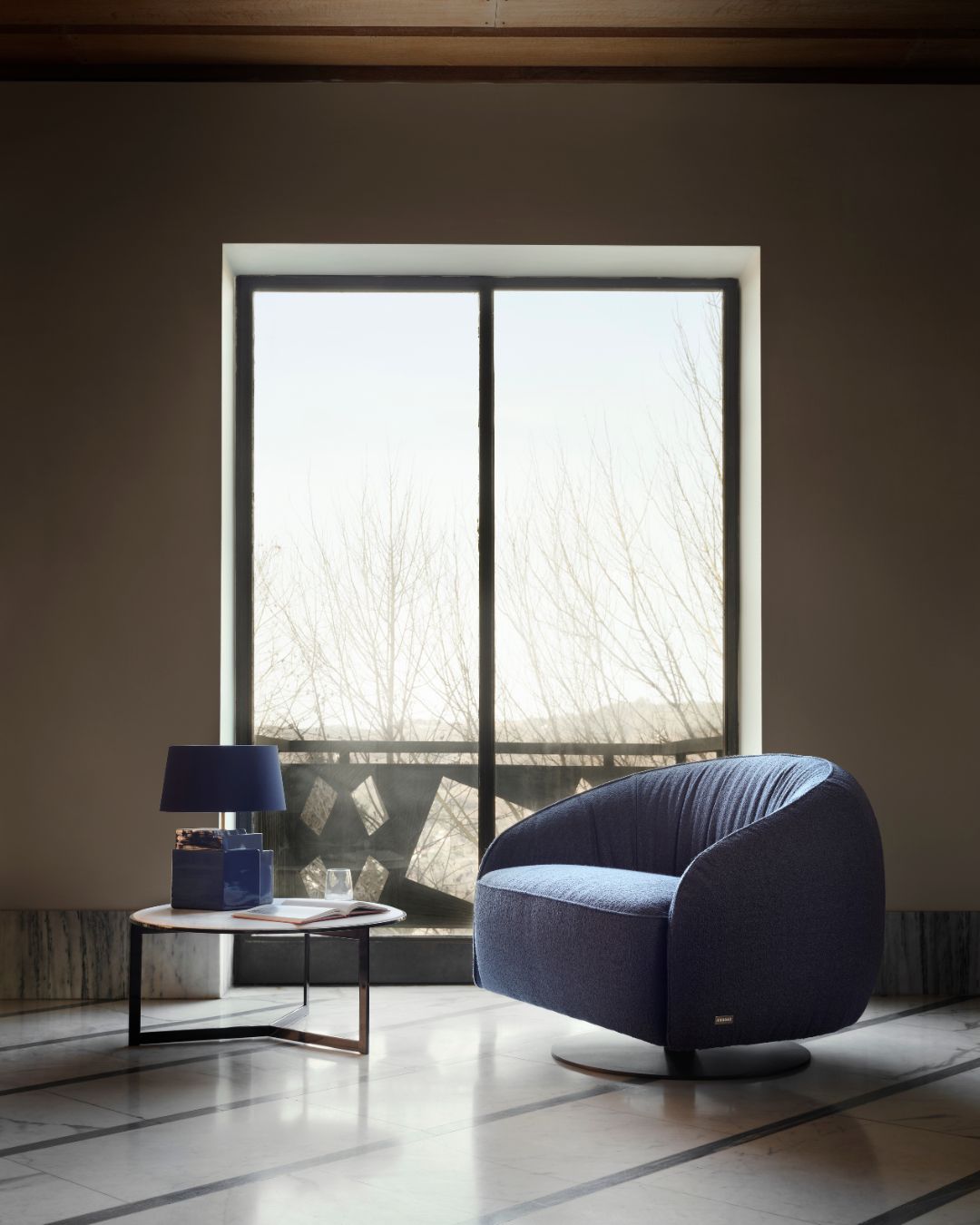 Nest fotelis iš Nicoline – apvalių, apgaubiančių formų, su žemu atlošu ir besisukančia baze