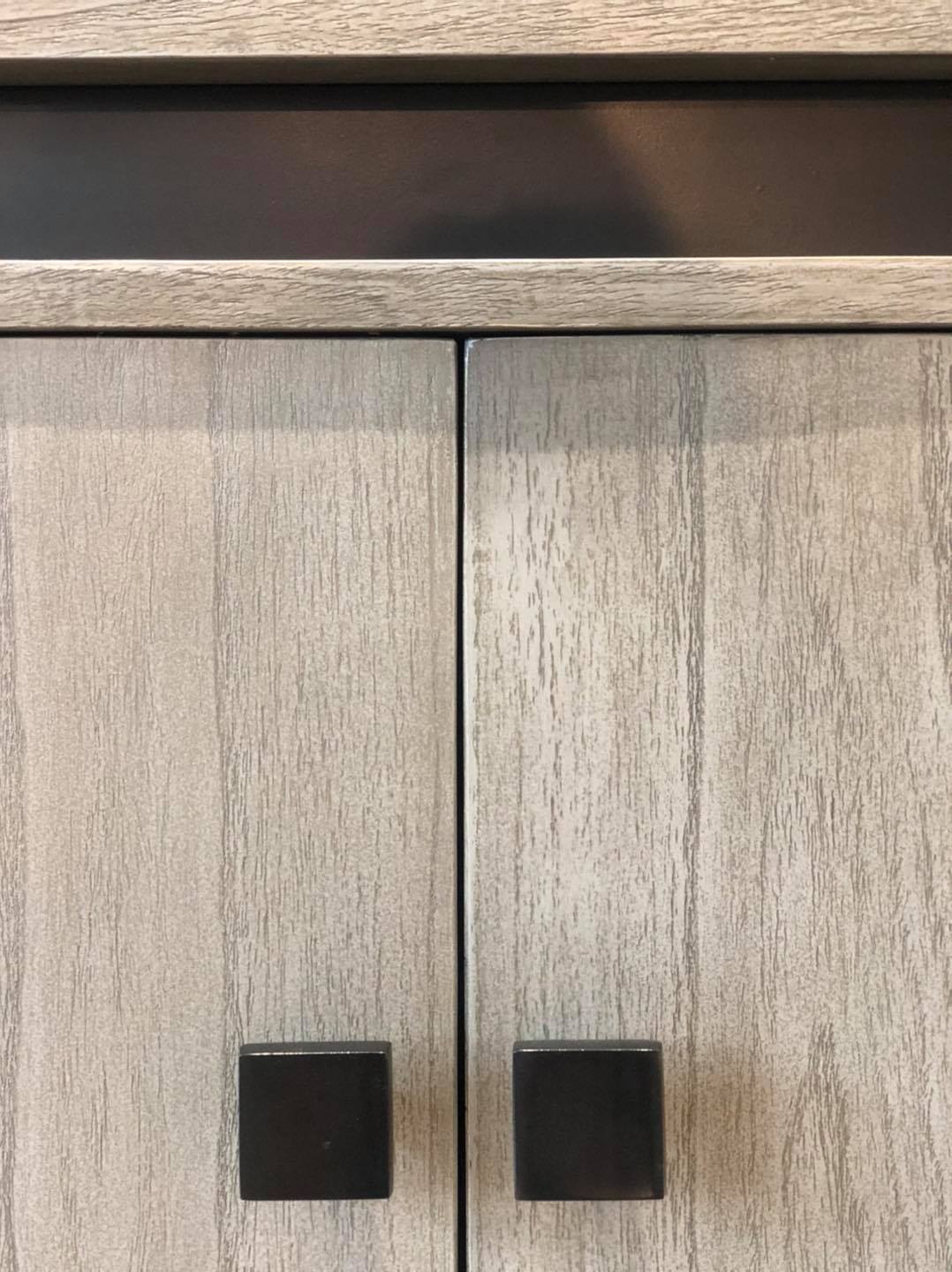 Pilkšvos medienos spalvos stilinga komoda su juodomis rankenėlėmis iš Thai Natura