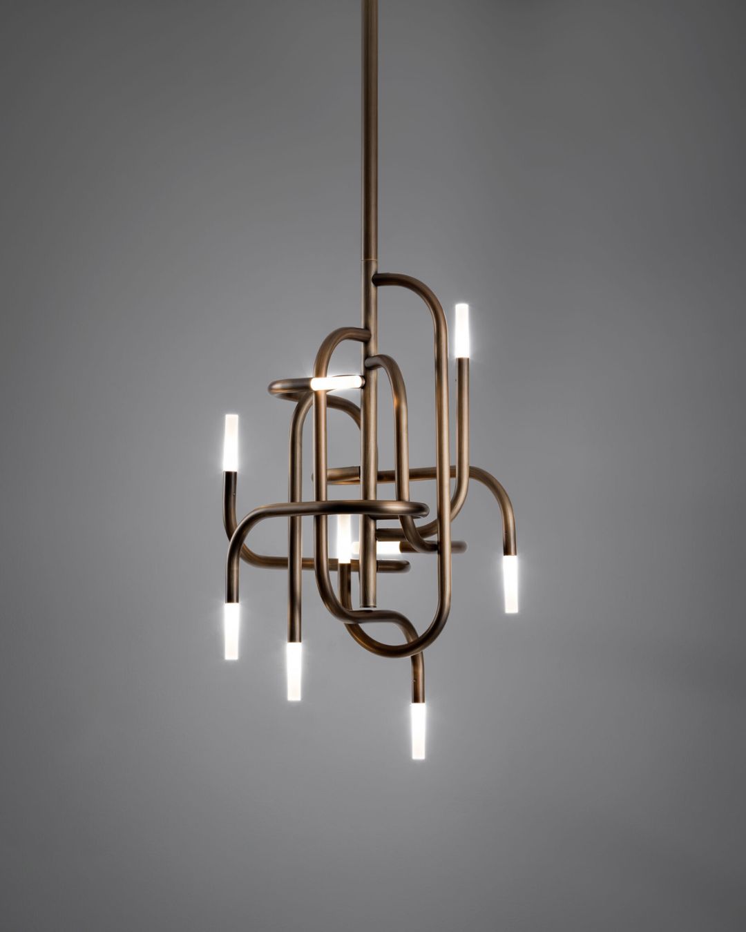 Sentinto žalvario spalvos pakabinamas šviestuvas iš raizgytų vamzdelių