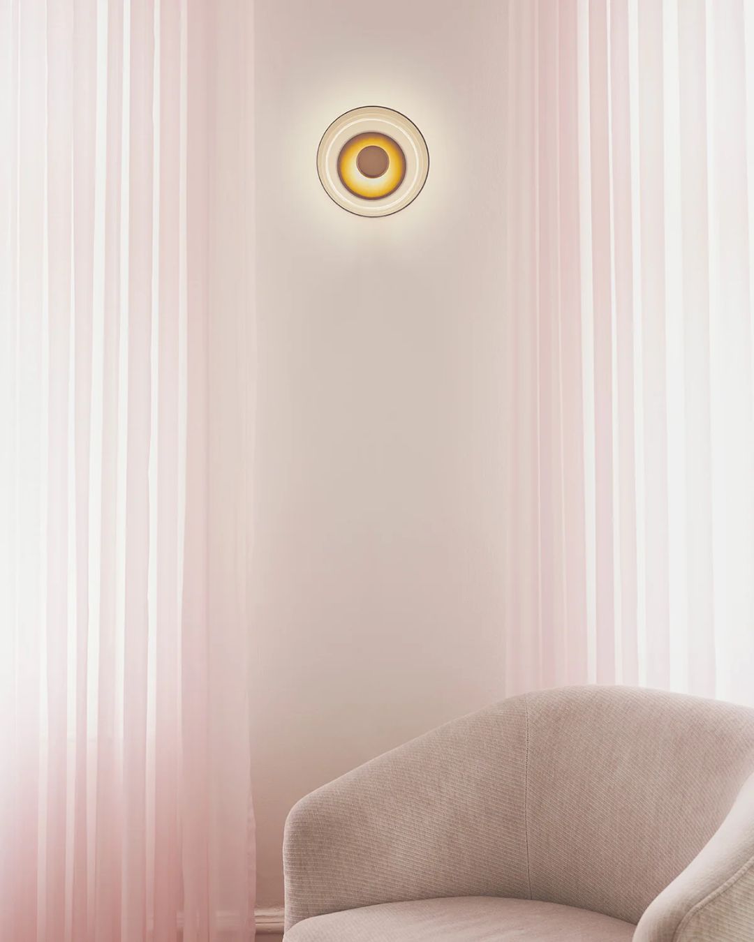 Apvalus sieninis šviestuvas su skaidraus stiklo gaubtu ir aukso detalėmis iš Nuura Lighting