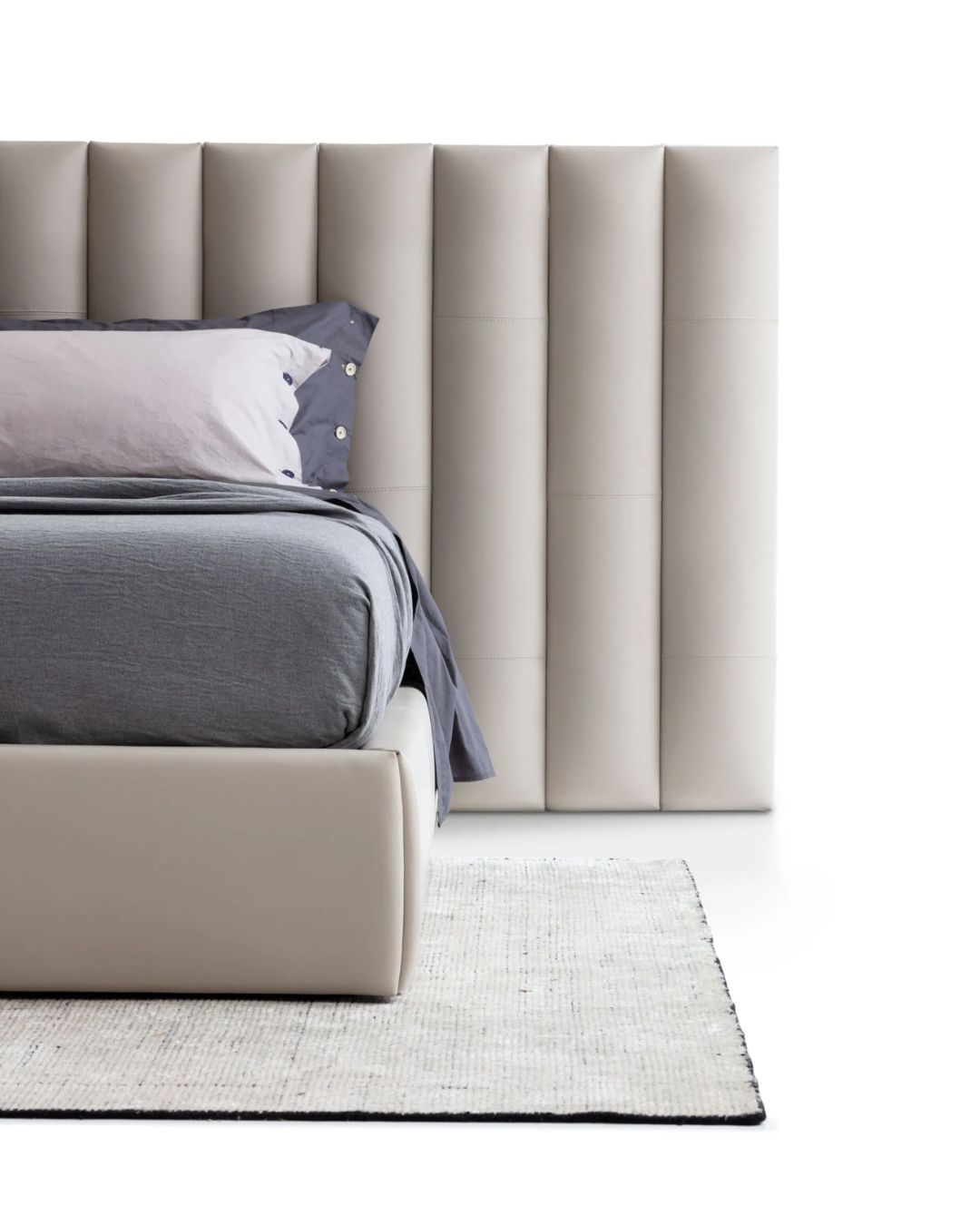 Šviesios spalvos miegamojo lova su didele atkalte. Nuotrauka baltame fone.