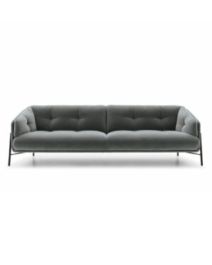 Tamsiai polkos spalvos trivietė sofa su juodomis metalinėmis kojelėmis. Nuotrauka baltame fone.