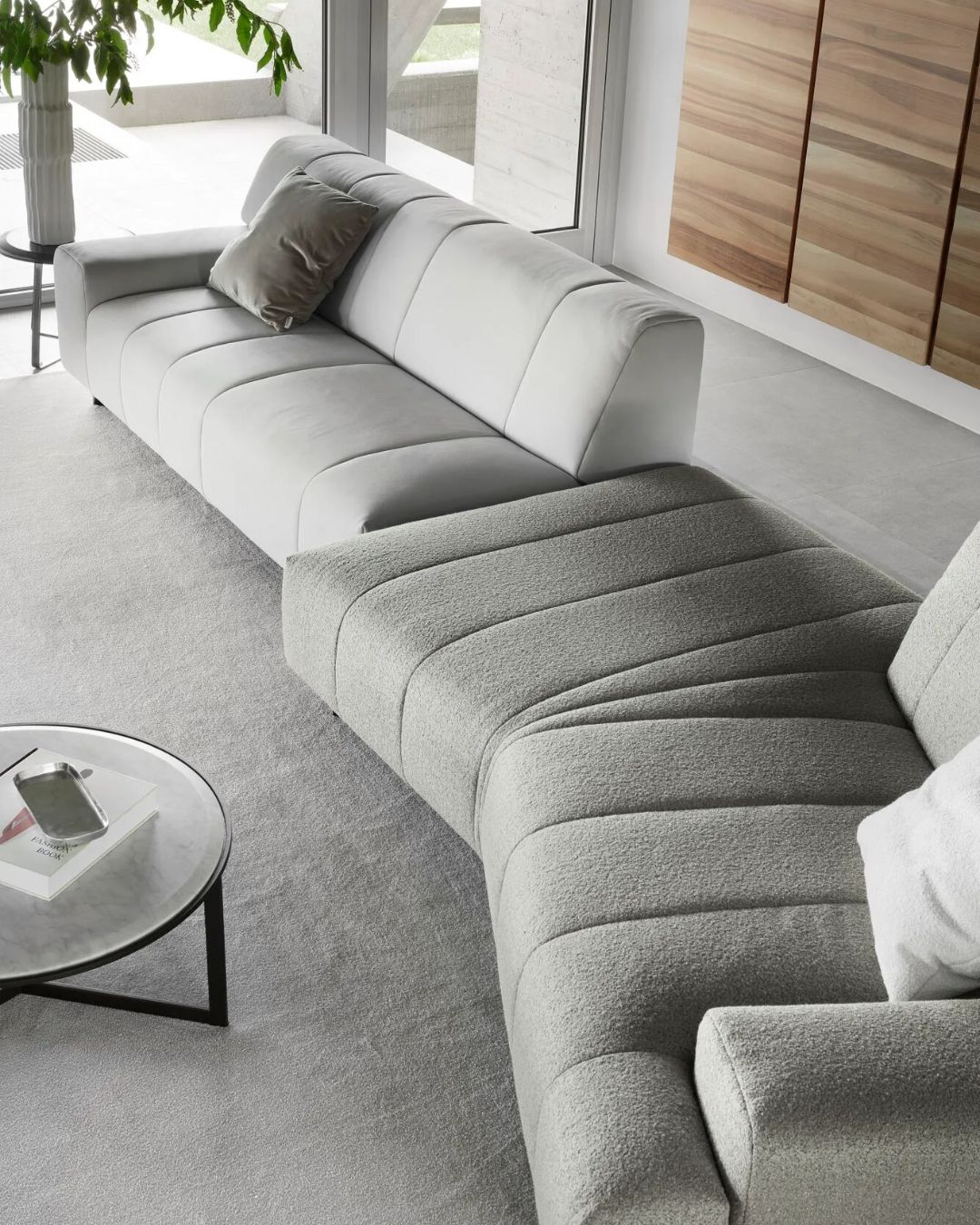 Pilkos spalvos moderni sofa minimalistiniame interjere