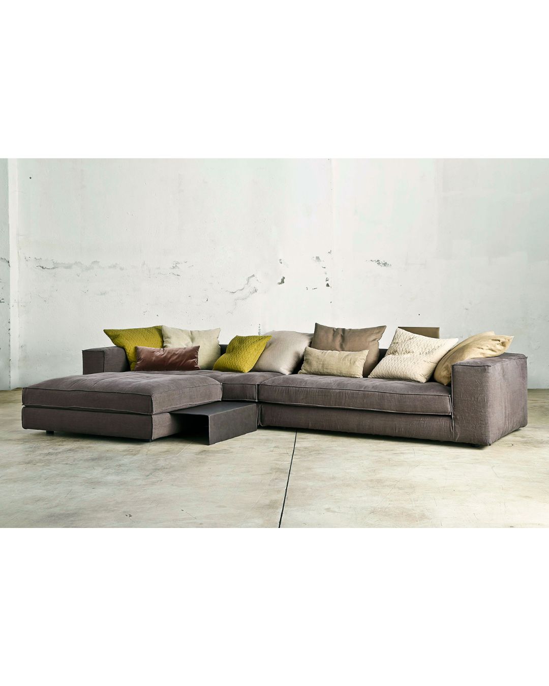 Didžiulė pilka svetainės sofa su daug skirtingos spalvos pagalvėlių